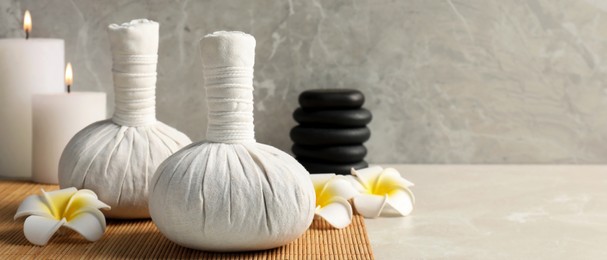 Image of Spa bags, stones and scented candles on light gray table, space for text. Banner design