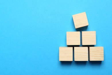 Photo of Blank cubes on light blue background, flat lay with space for text. Idea concept