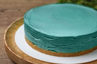 Photo of Delicious homemade spirulina cheesecake on wooden table