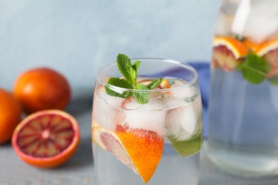 Photo of Delicious refreshing drink with sicilian orange and mint on grey table, closeup