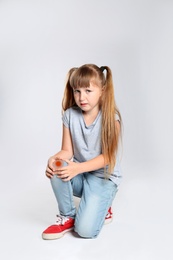 Photo of Full length portrait of little girl suffering from knee problems on grey background
