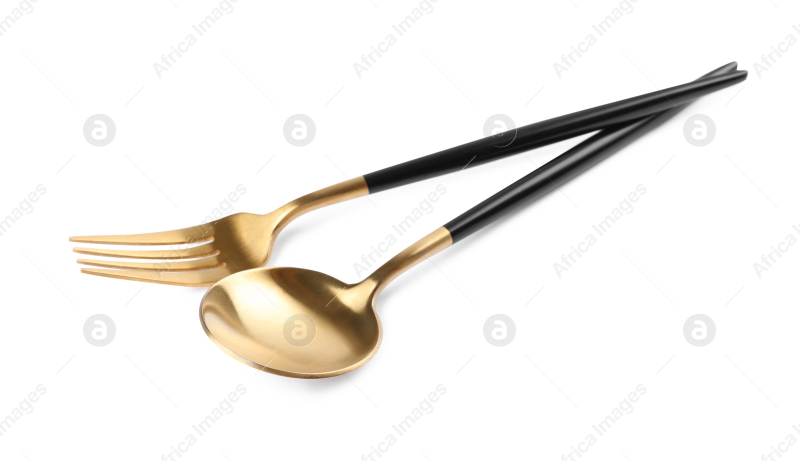 Photo of New golden fork and spoon with black handles on white background