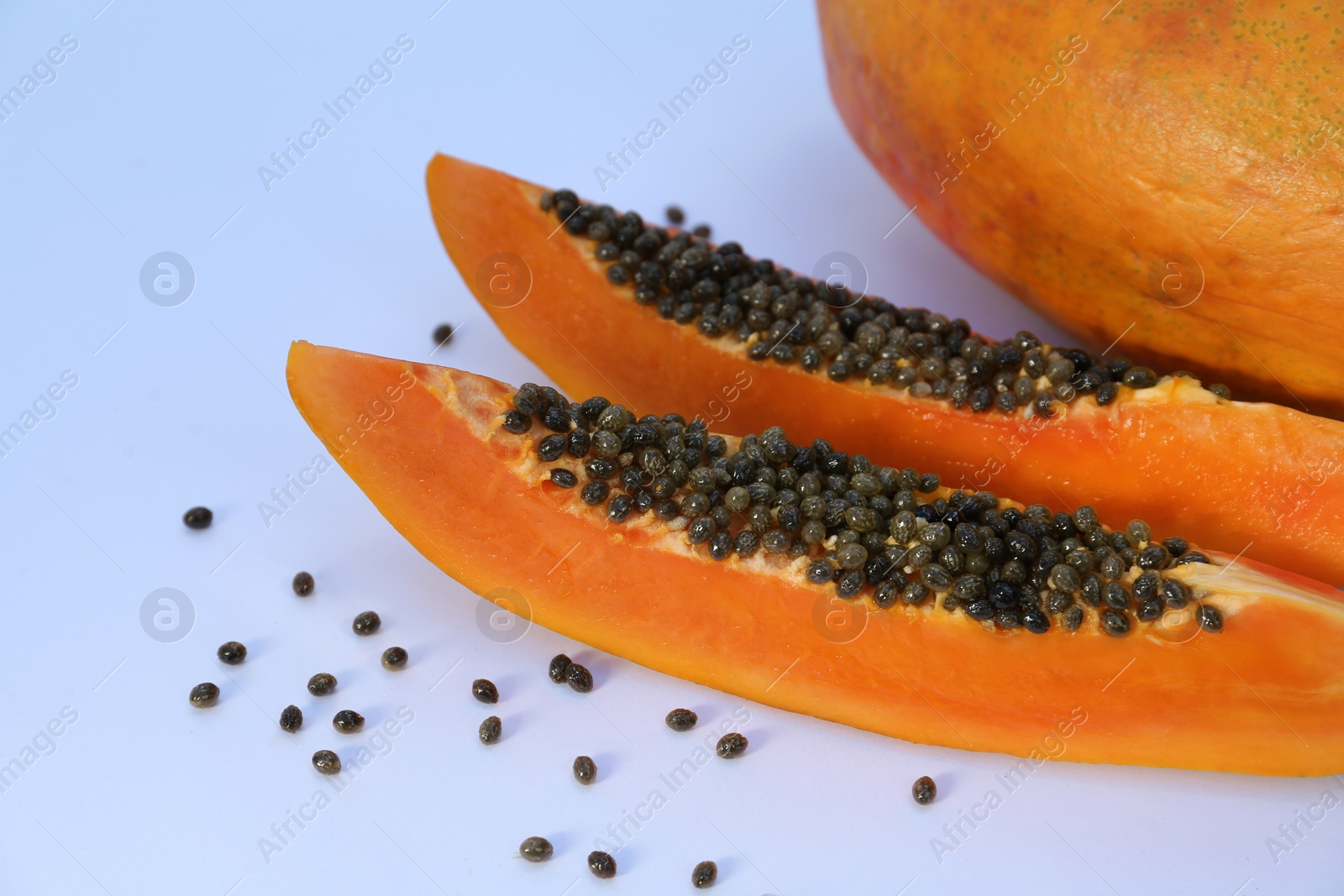 Photo of Fresh juicy cut and whole papaya fruits on white background, closeup