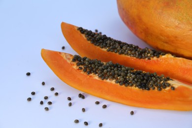 Photo of Fresh juicy cut and whole papaya fruits on white background, closeup