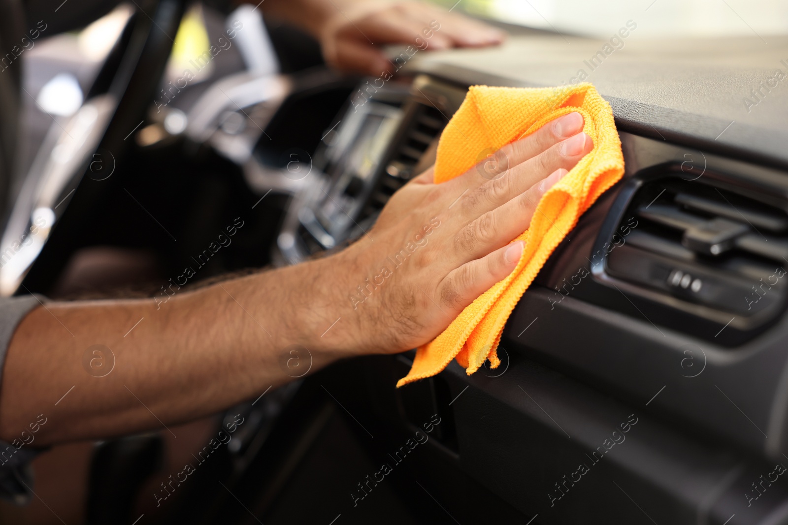 Photo of Man cleaning car interior with rag, closeup