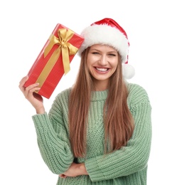 Happy young woman in Santa hat with Christmas gift on white background