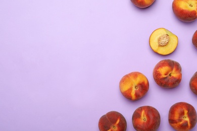 Photo of Sweet juicy peaches on lilac background, top view. Space for text