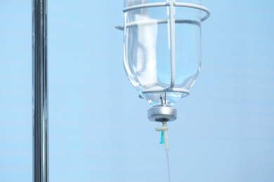 Photo of IV drip on light blue background, closeup