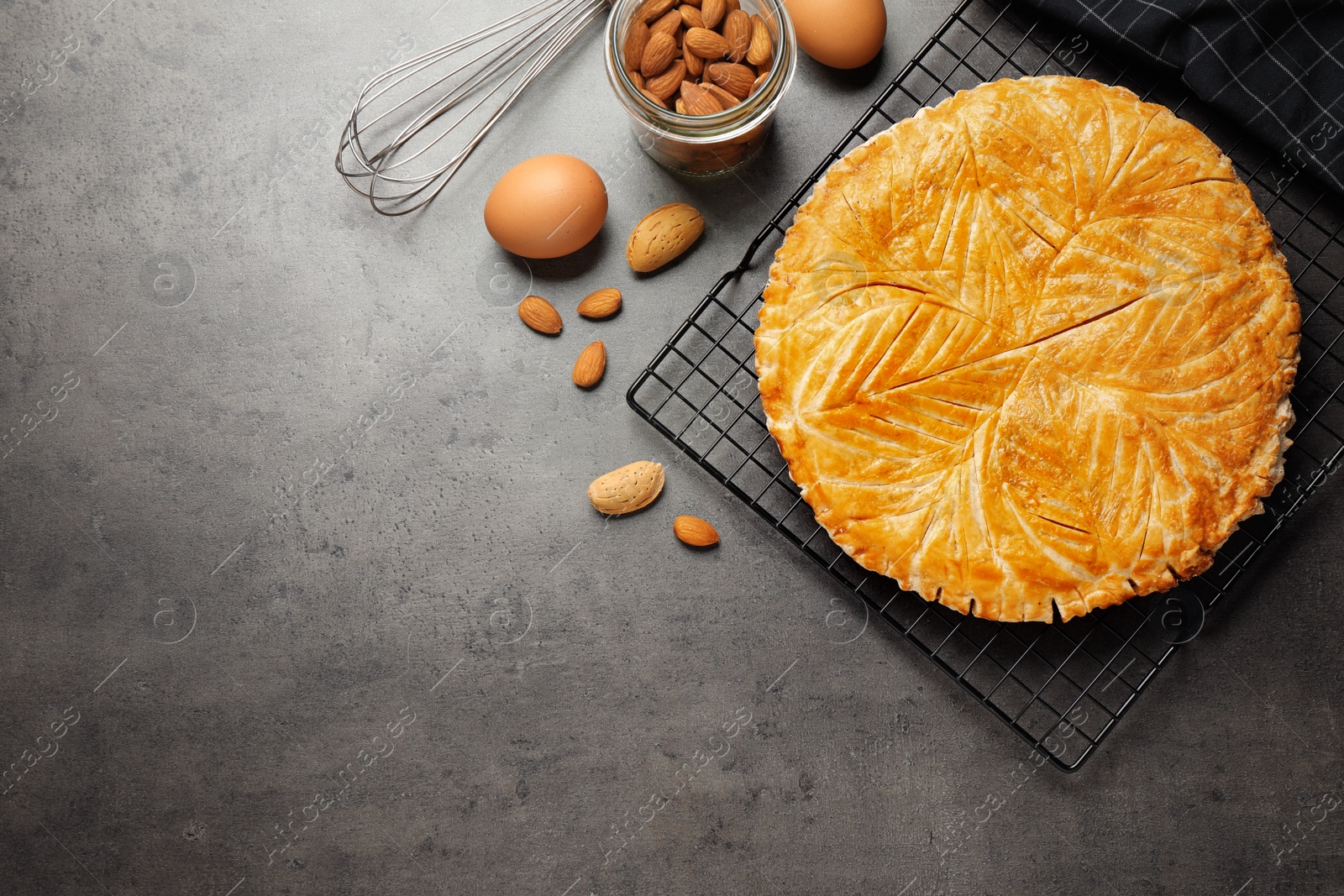 Photo of Traditional galette des rois and ingredients on grey table, flat lay. Space for text