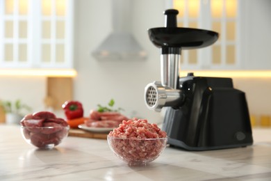 Photo of Modern grinder in kitchen, focus on bowl of minced meat. Space for text