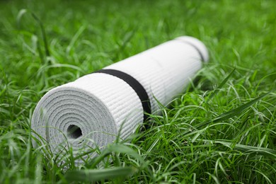 White karemat or fitness mat on green grass outdoors, closeup