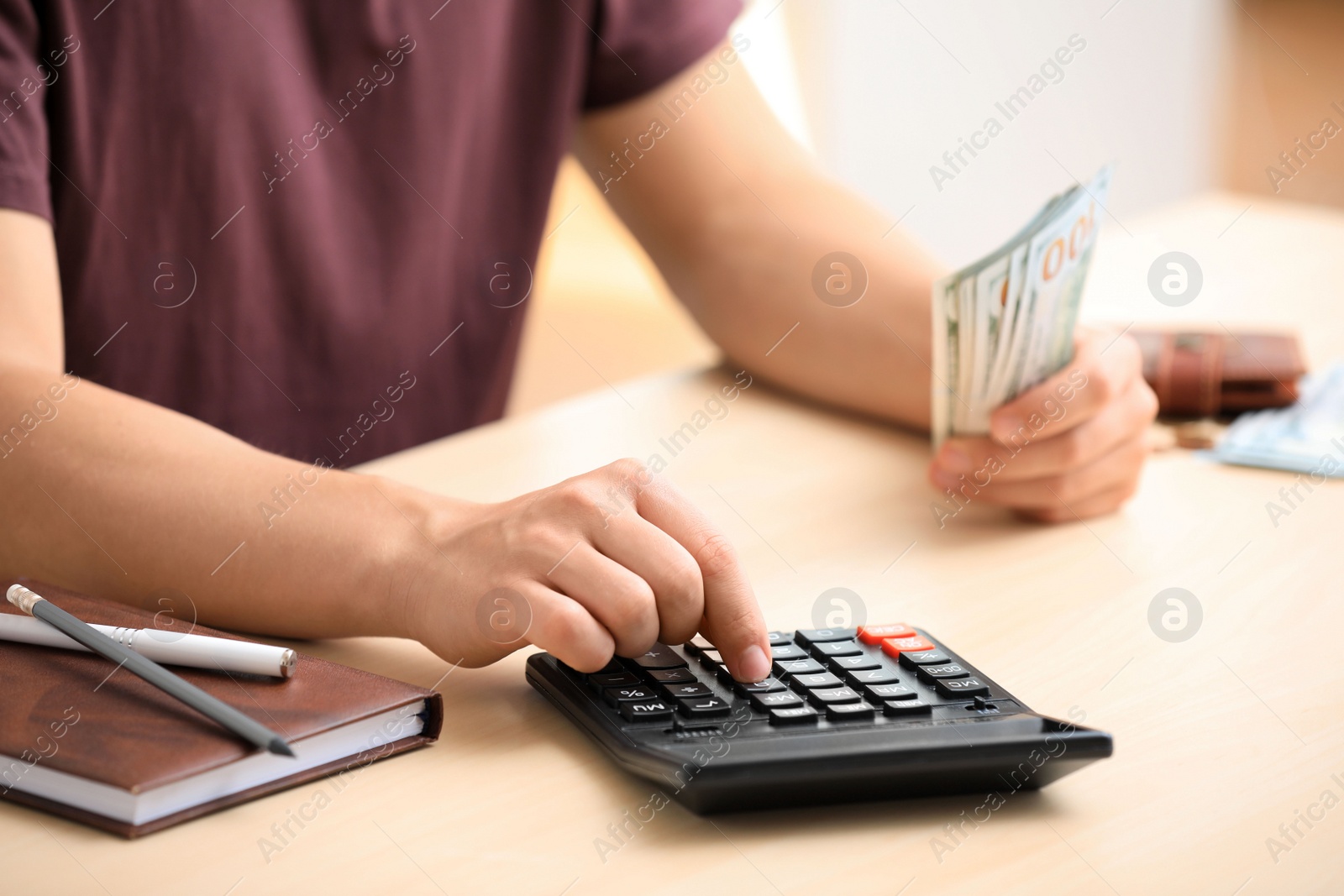 Photo of Man counting American money at table, closeup