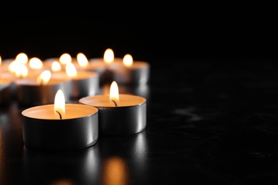 Photo of Burning candles on table in darkness, space for text. Funeral symbol