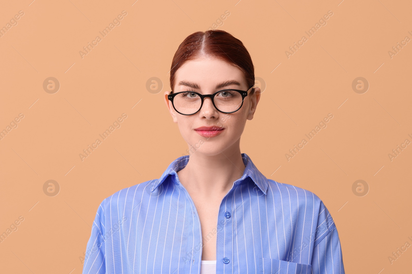 Photo of Portrait of beautiful woman in glasses on beige background