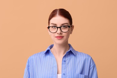 Photo of Portrait of beautiful woman in glasses on beige background