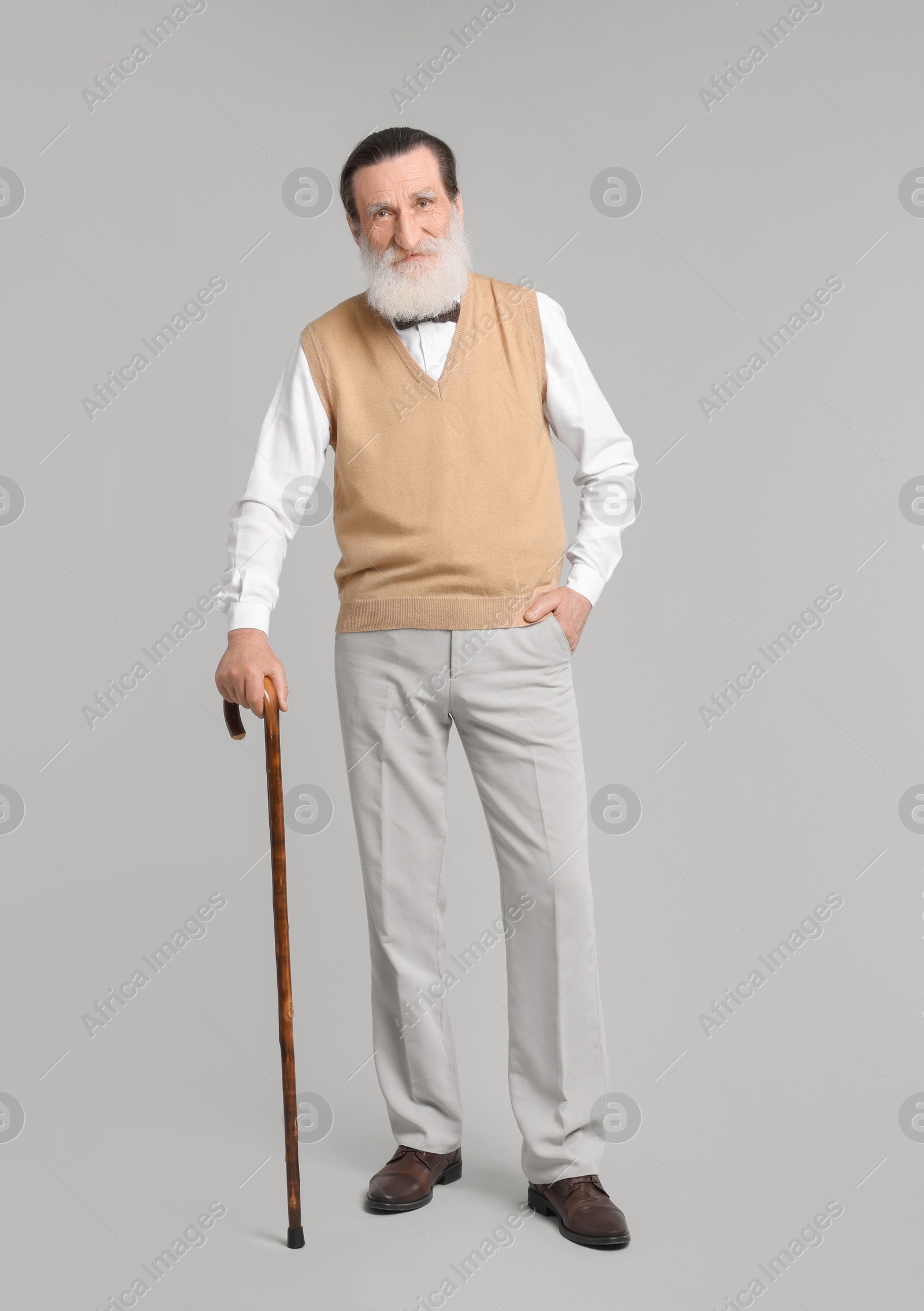 Photo of Senior man with walking cane on light gray background