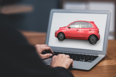 Buying online. Woman choosing car using laptop, closeup view