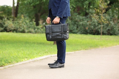 Businessman with black briefcase in hand outdoors