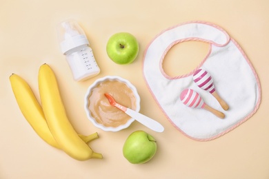 Photo of Flat lay composition with bowl of healthy baby food on color background