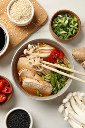 Delicious ramen with meat and ingredients on white marble table, flat lay. Noodle soup