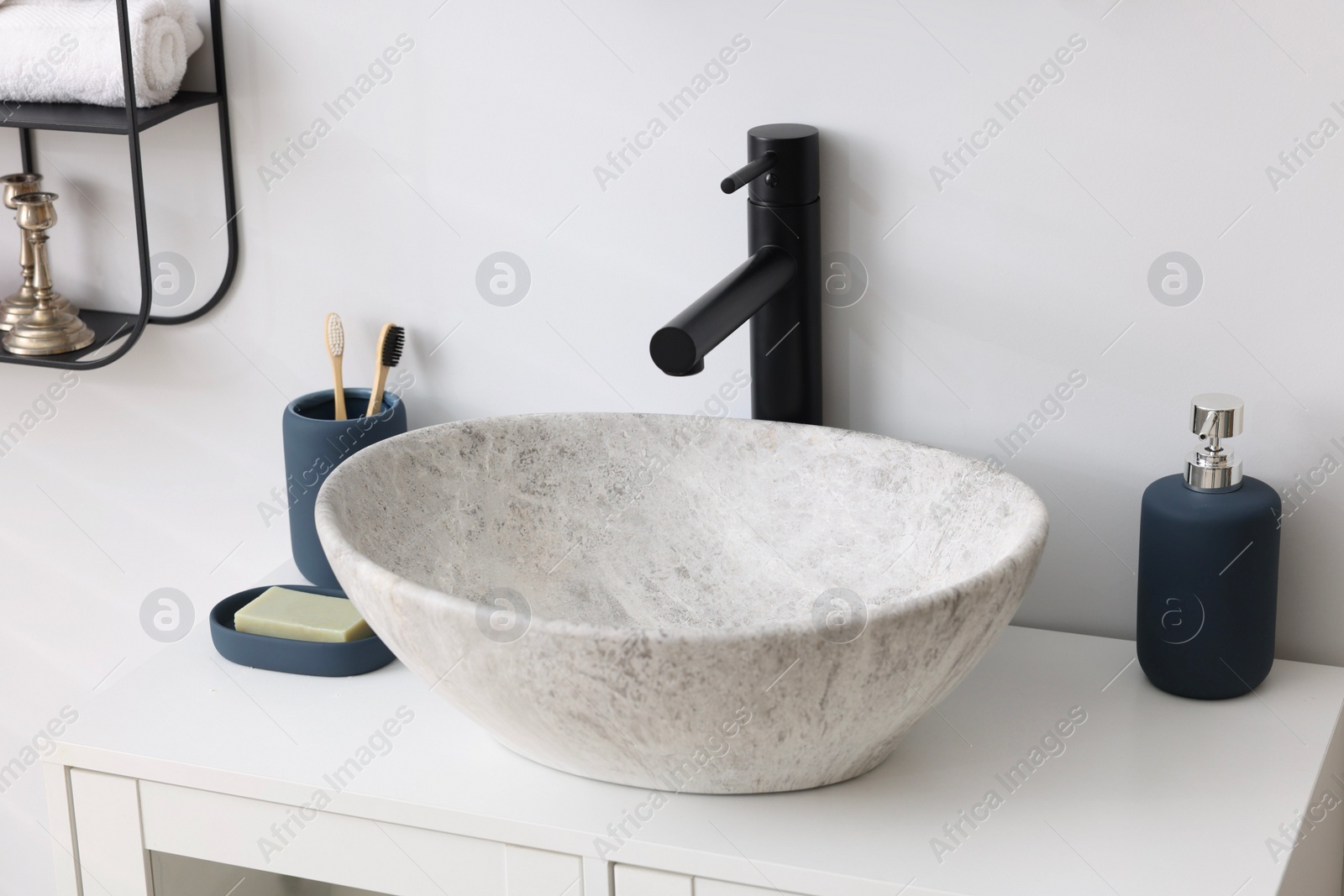 Photo of Different bath accessories and personal care products near sink on bathroom vanity