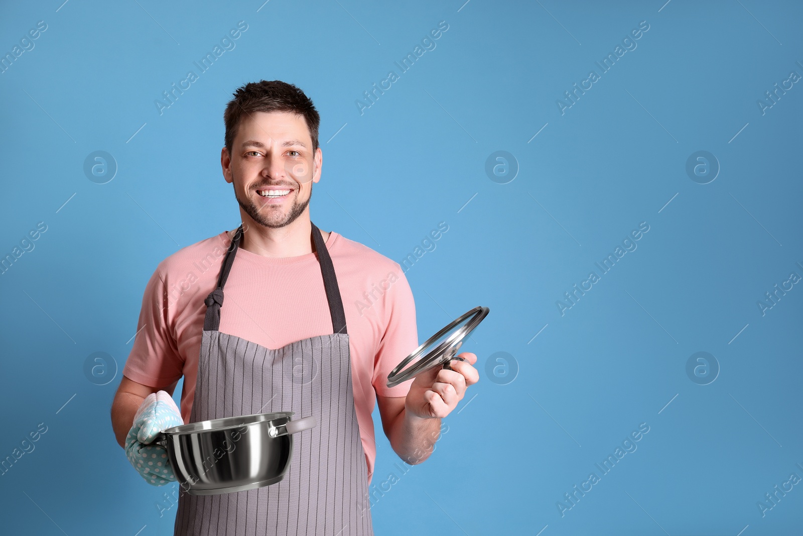 Photo of Happy man with pot on light blue background. Space for text