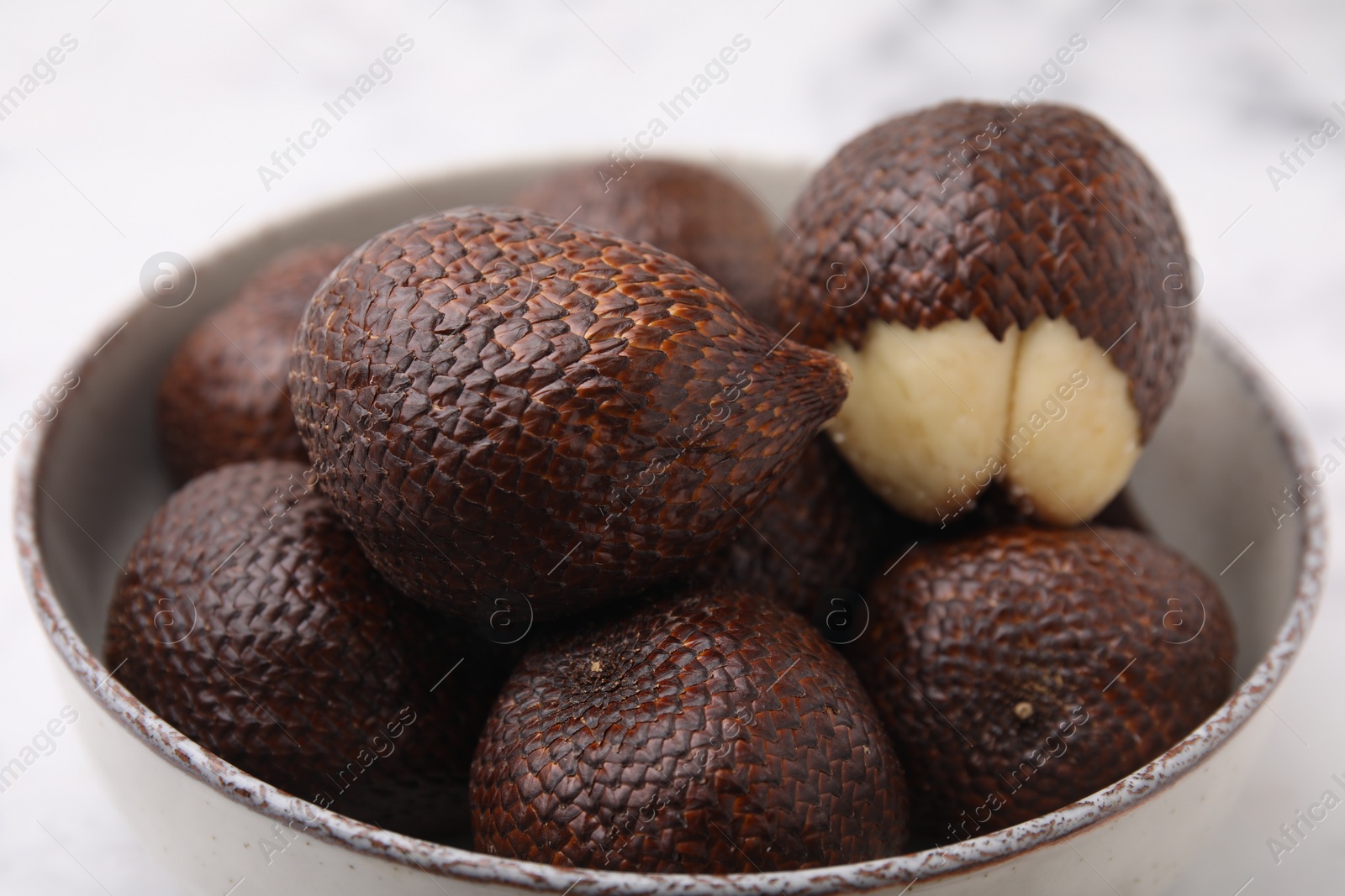 Photo of Fresh salak fruits in bowl on table, closeup
