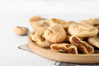 Photo of Tasty dried figs on white wooden table, closeup