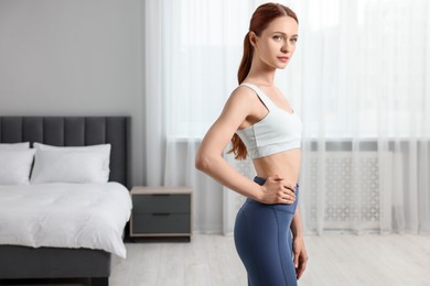 Photo of Woman wearing sportswear in bedroom, space for text