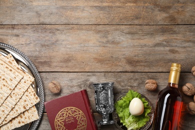 Photo of Flat lay composition with symbolic Passover (Pesach) items on wooden background, space for text