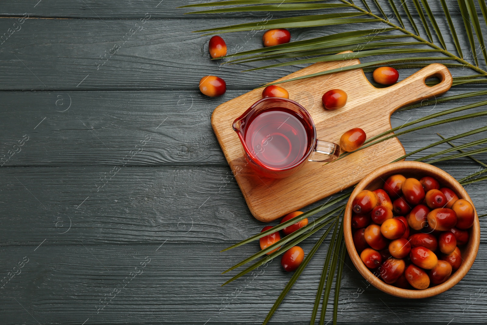 Photo of Flat lay composition with palm oil and fresh fruits on grey wooden table. Space for text