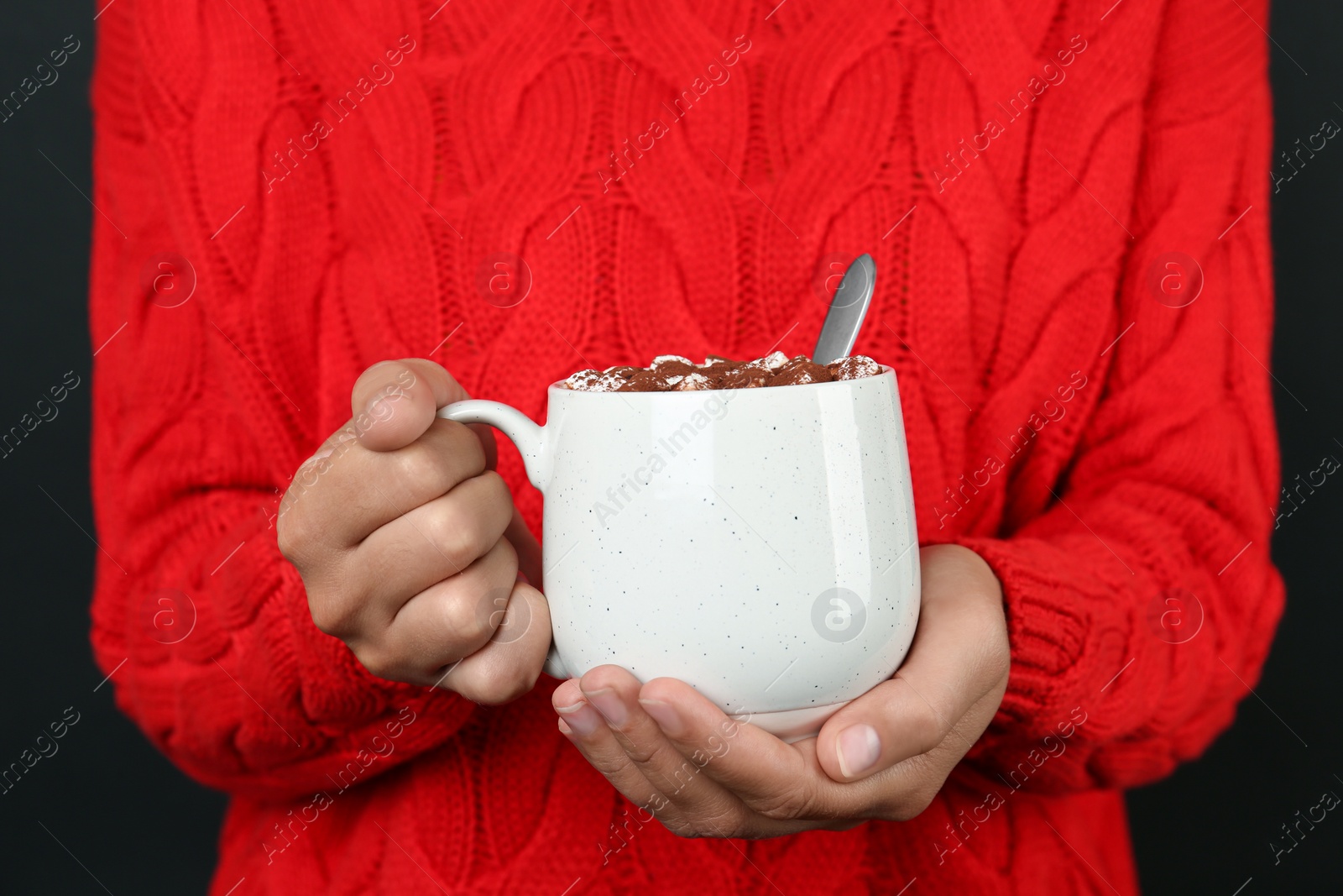 Photo of Woman holding cup of delicious hot cocoa drink with marshmallows, closeup