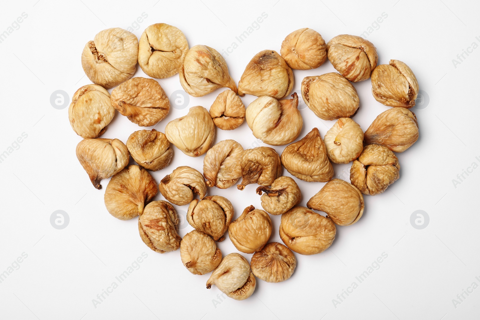 Photo of Heart shaped heap of dried figs on white background, top view. Healthy fruit