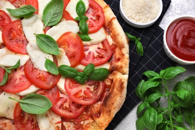 Delicious Caprese pizza with tomatoes, mozzarella and basil on table, flat lay