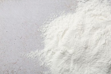 Photo of Baking powder on light textured table, top view. Space for text