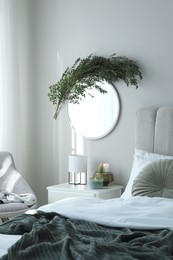 Stylish mirror decorated with green eucalyptus in bedroom