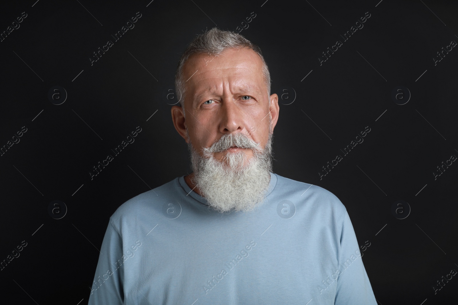 Photo of Portrait of handsome senior man on black background