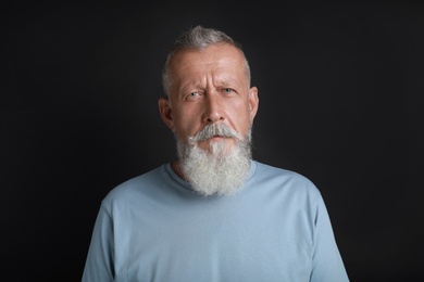 Photo of Portrait of handsome senior man on black background