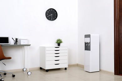 Photo of Modern water cooler in stylish office interior