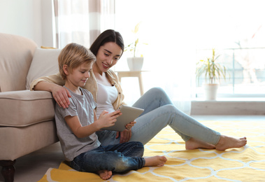 Mother and son reading E-book together at home
