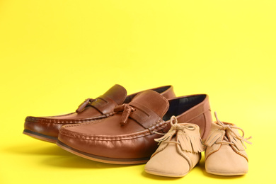 Photo of Dad and son's shoes on yellow background. Happy Father's Day