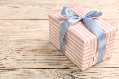 Elegant gift box with bow on wooden background