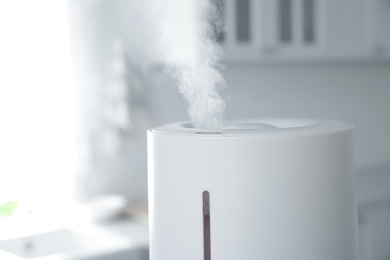 Photo of Modern air humidifier in kitchen, closeup view