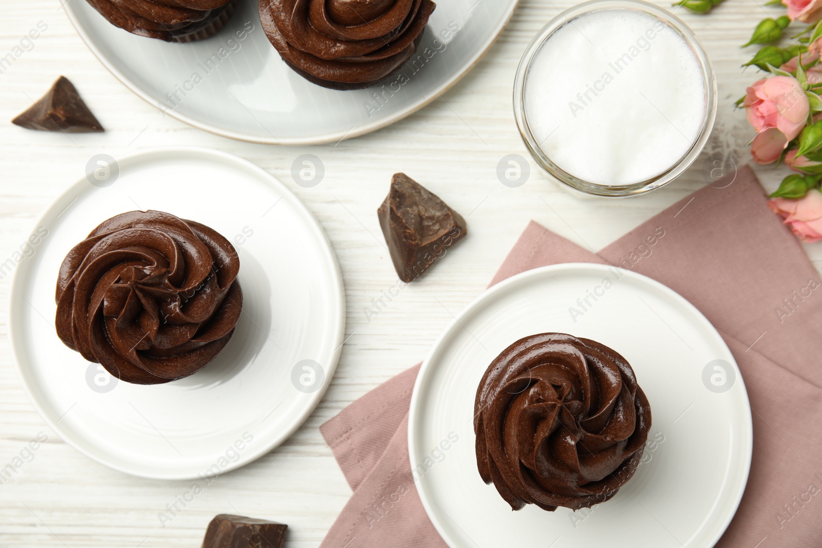 Photo of Flat lay composition with delicious chocolate cupcakes on white wooden table