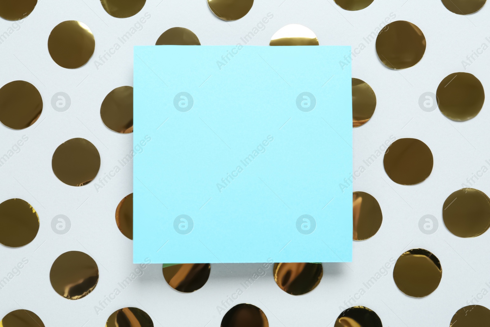Photo of Blank card and shiny golden confetti on white background, flat lay. Space for text
