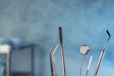 Photo of Professional dentist tools on blurred background, space for text