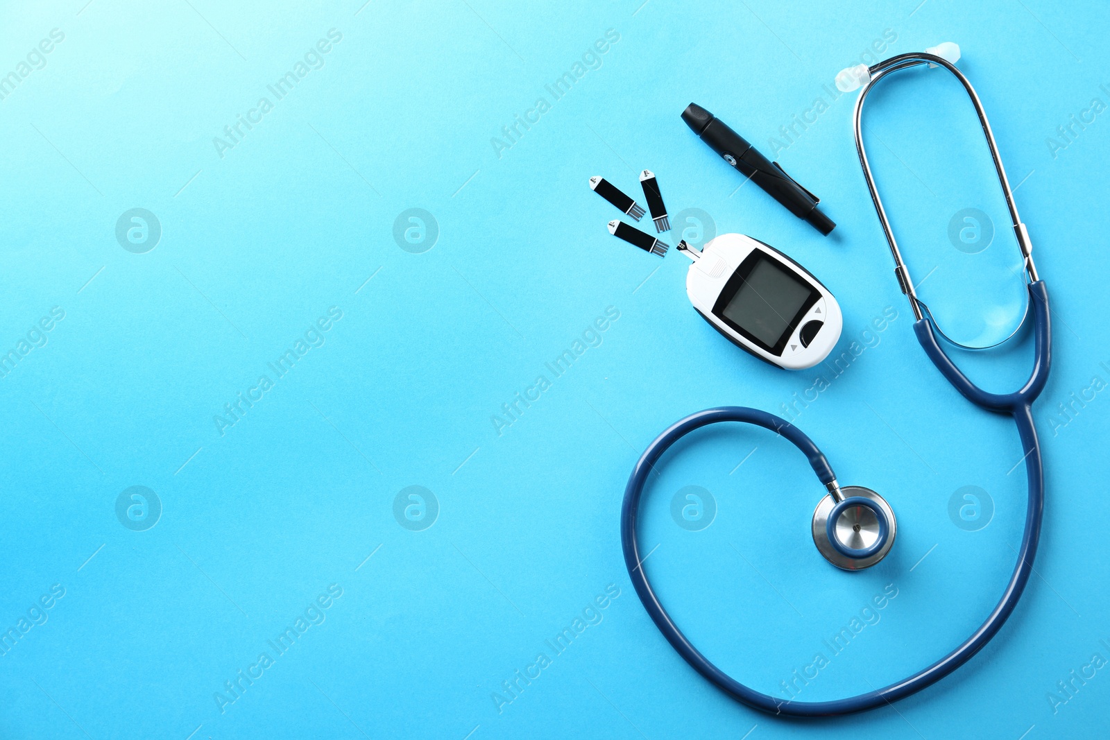 Photo of Flat lay composition with glucose meter and stethoscope on light blue background. Space for text