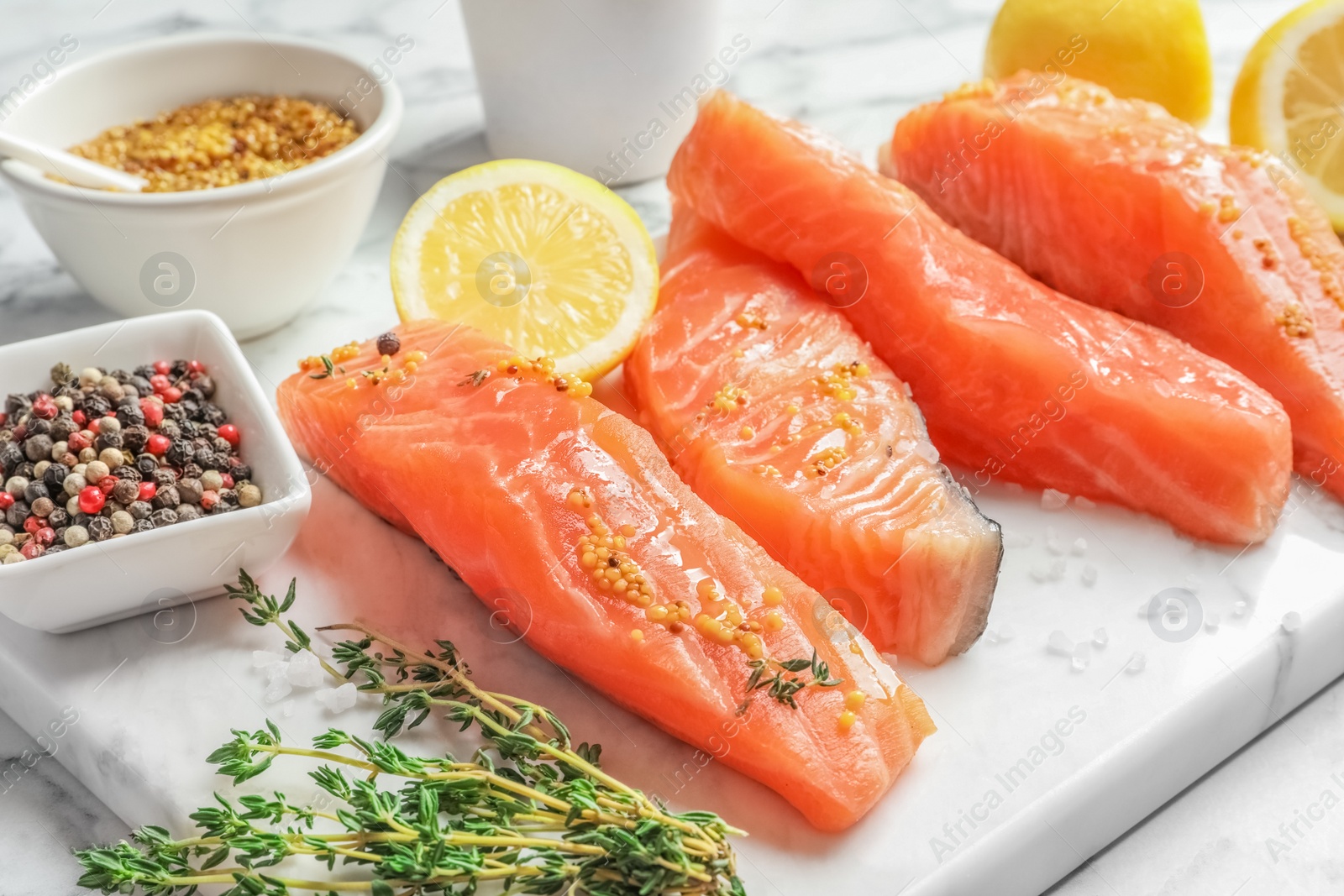 Photo of Fresh salmon and ingredients for marinade on marble board