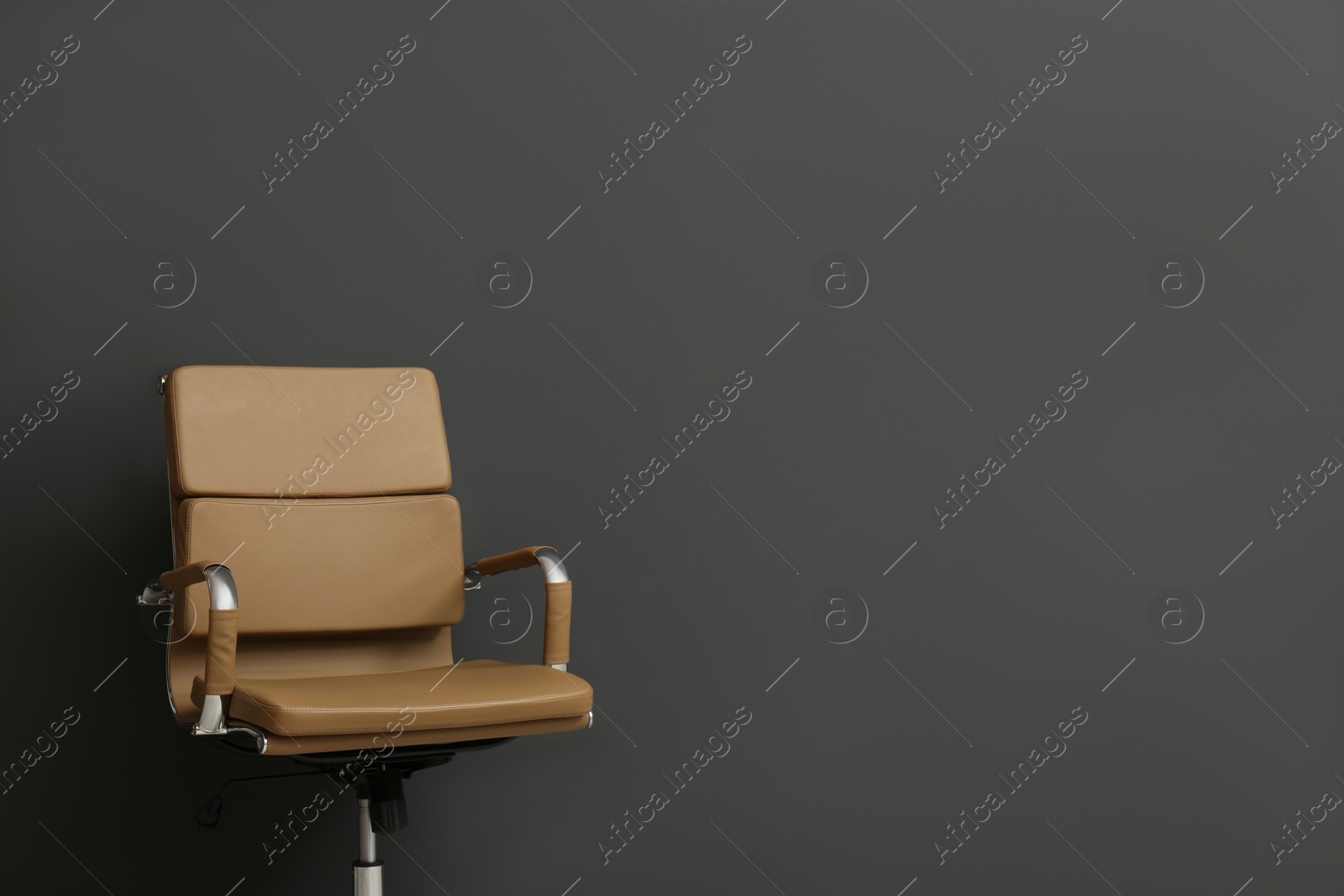 Photo of Comfortable office chair on black background. Space for text