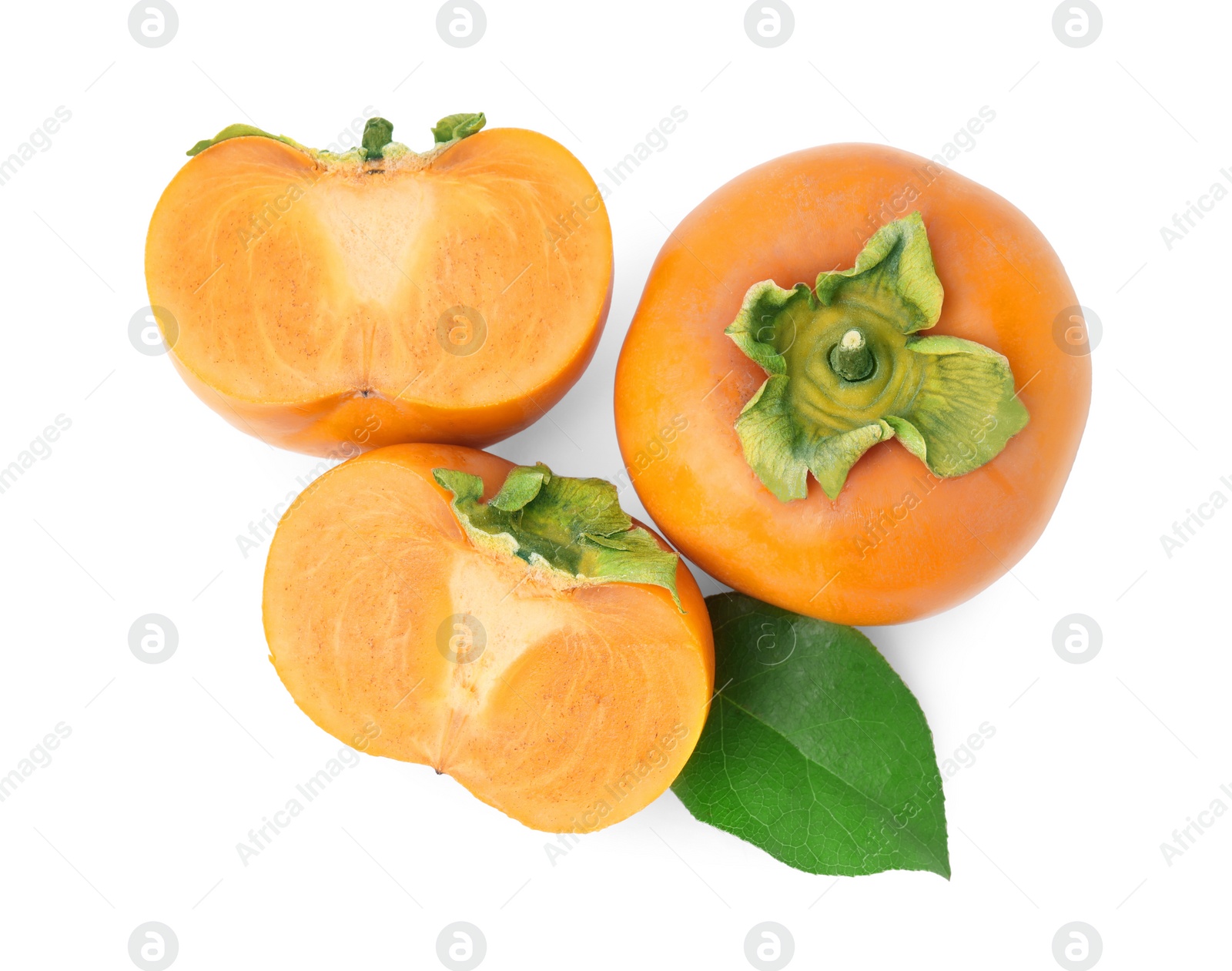 Photo of Whole and cut delicious ripe juicy persimmons with green leaf on white background, top view